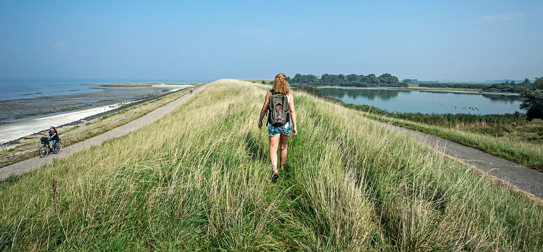 vrouw wandelt over een dijk