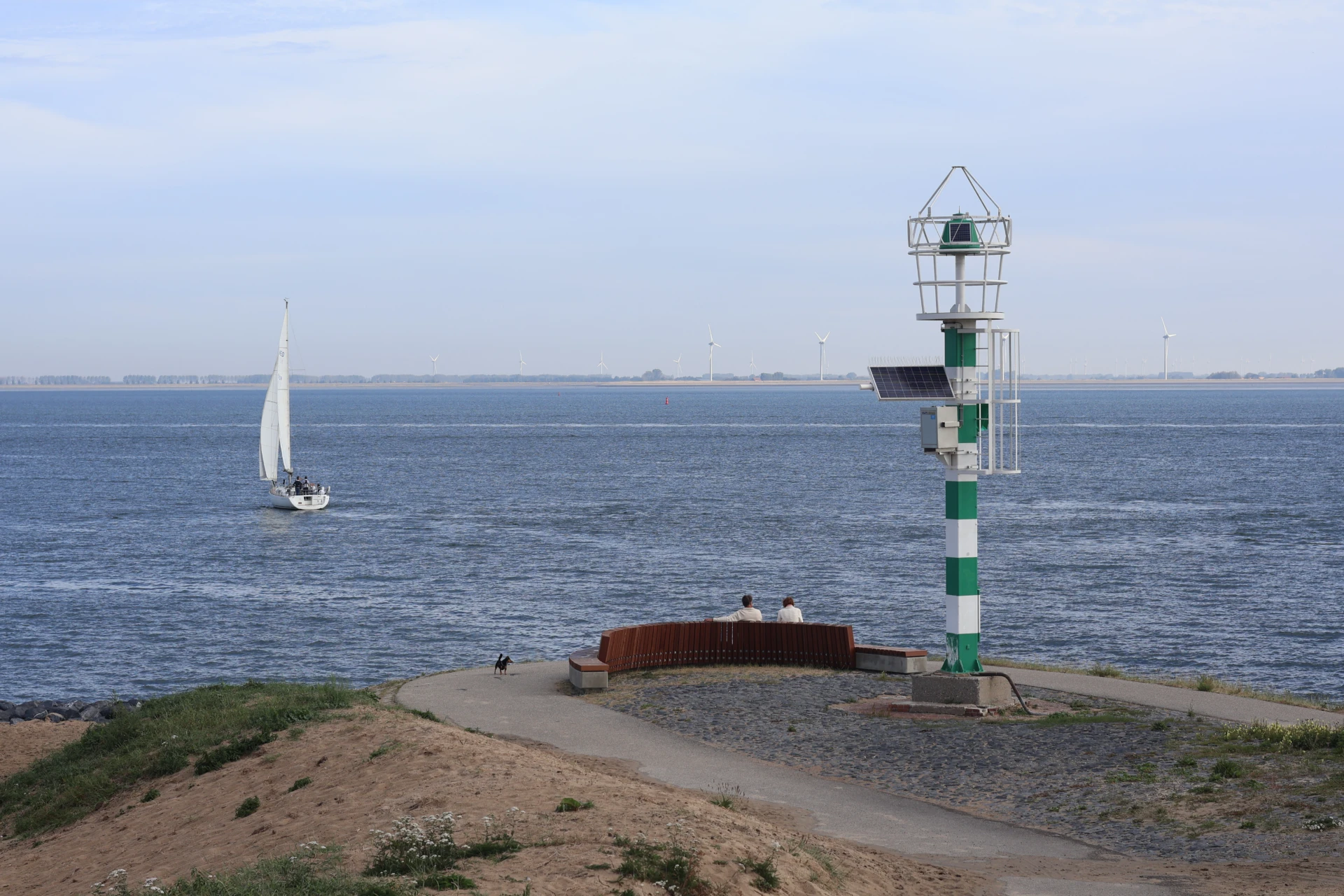 Mensen genieten op een bank langs de Oosterschelde bij Wemeldinge